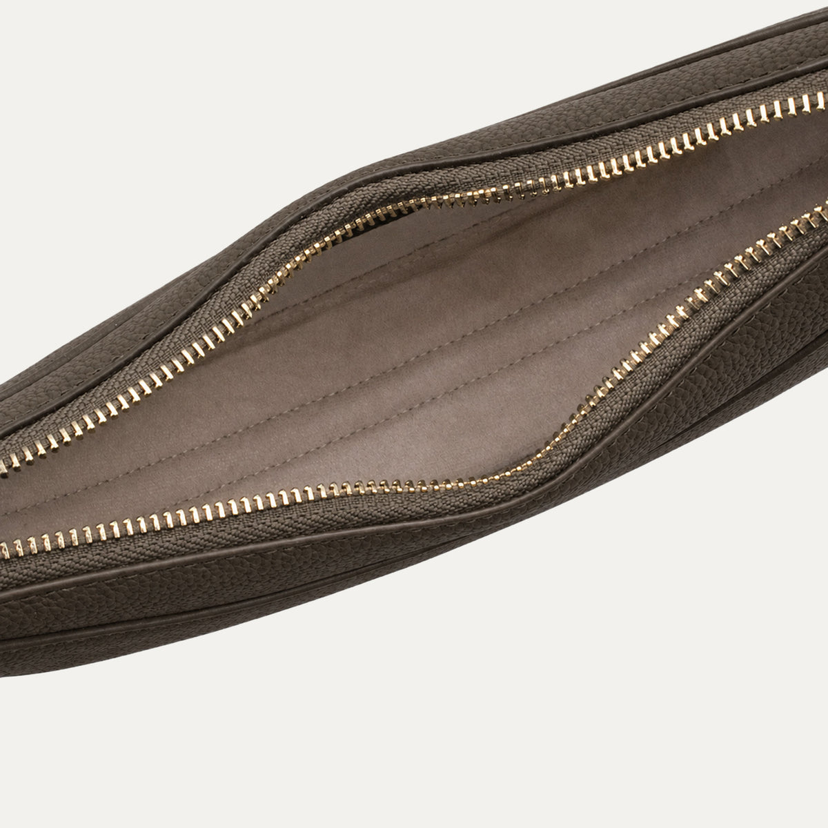 Close-up of a dark brown textured leather zippered pouch with gold-tone metal zippers, shown against a light gray background.