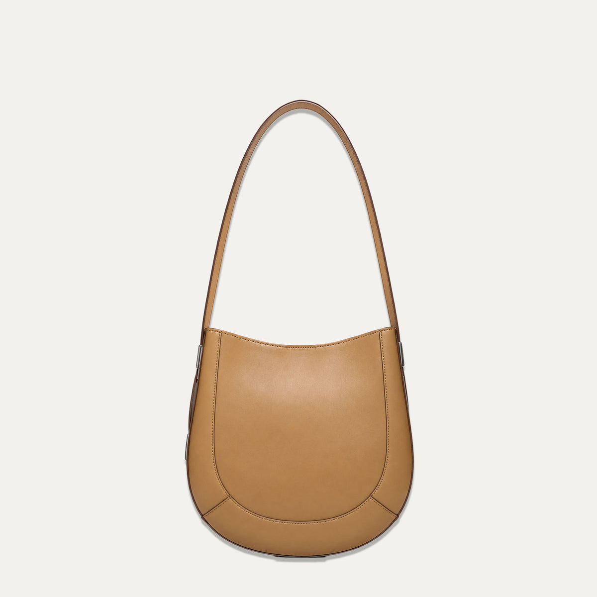 A tan leather crescent-shaped shoulder bag with a single strap, photographed against a solid off-white background.