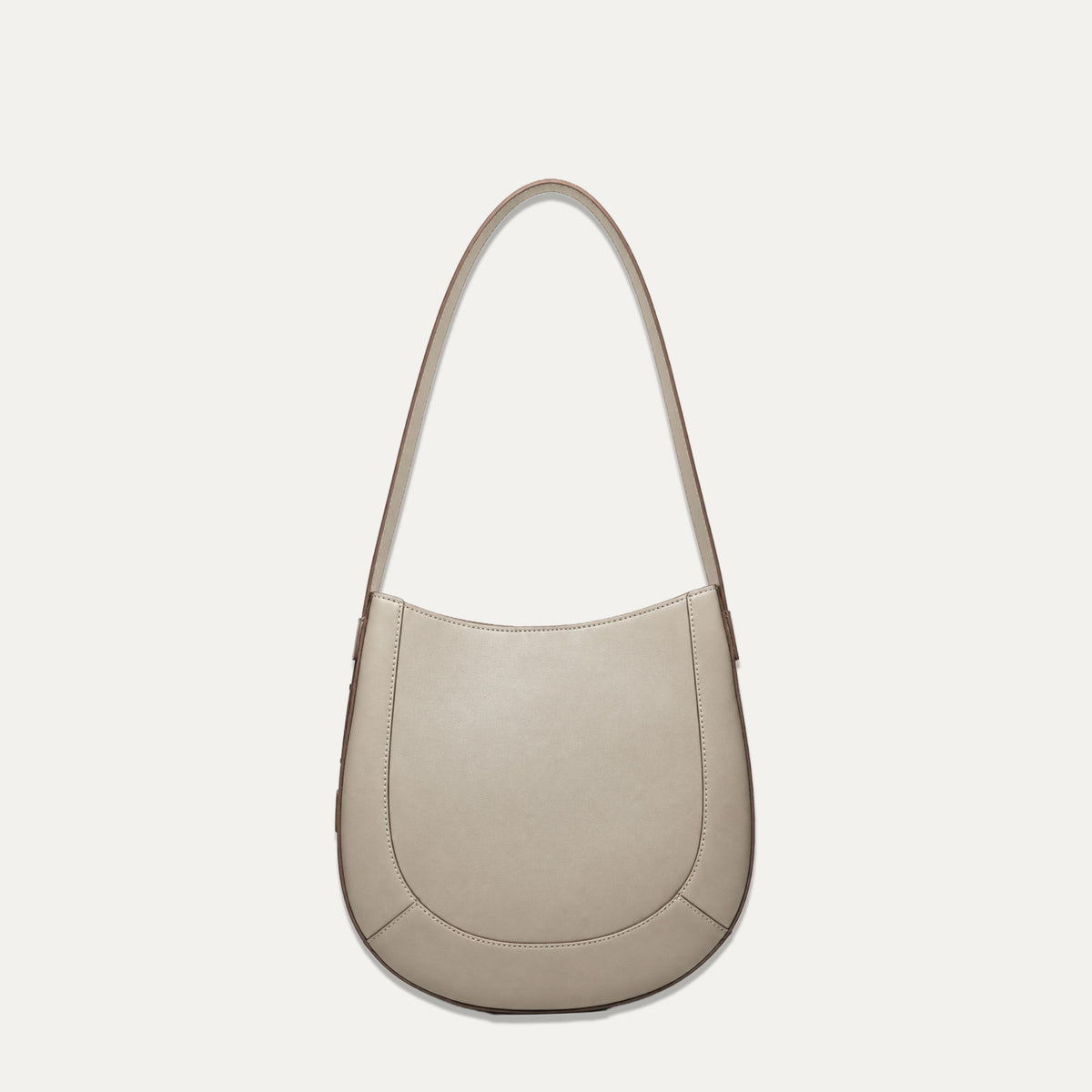 A taupe leather crescent-shaped shoulder bag with a single strap, shown against a solid off-white background.