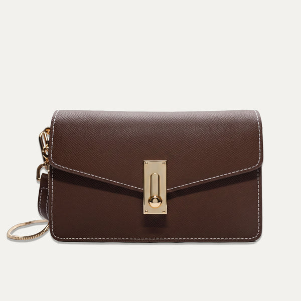 A dark brown textured leather crossbody bag with a gold-tone turn-lock clasp and a matching gold-tone chain strap, shown against a light off-white background.